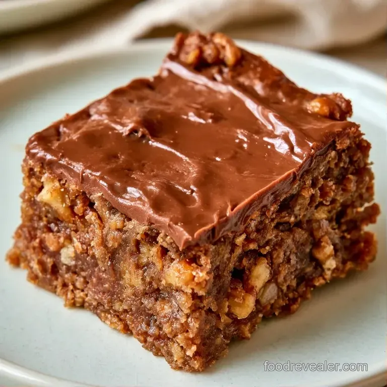 Three rich cocoa squares stacked neatly on a white ceramic plate, garnished with a sprinkle of sea salt and mint.