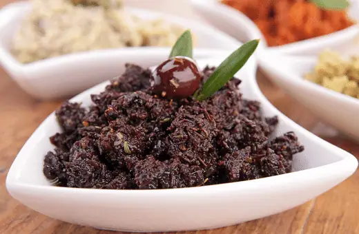 Tapenade provençal sauce is made with olives, anchovies, capers, olive oil, and vinegar. It is a piquant sauce that adds flavor to the grilled octopus without overwhelming it.
