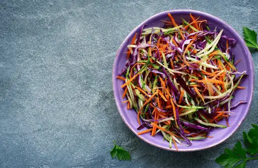 A light coleslaw has just enough crunchy cabbage mixed in with creamy mayonnaise-based dressing to balance out heavy flavors like those found in fried foods like onion rings!