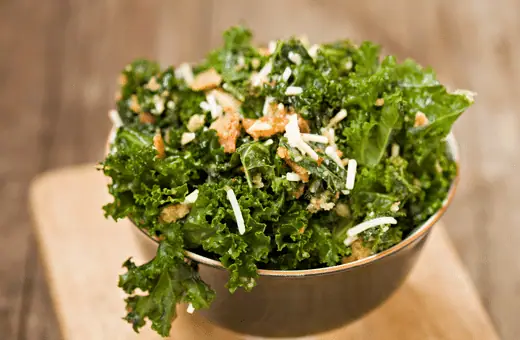 Massaged kale topped with toasted walnuts and a zesty lemon dressing is perfect for your charcuterie board.