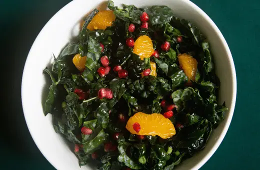 Rich kale is paired up beautifully with vibrant oranges in this zesty ginger-dressed salad, providing some excellent texture contrast to the creaminess of the grits below it.