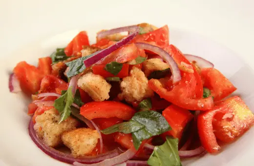 Panzanella salad is a traditional Tuscan dish with fresh and juicy tomatoes, onions, cucumbers, and bread. The bread is lightly toasted and soaked in tomato juices, giving it an incredibly juicy texture. 
